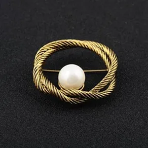 Close-up of vintage wheat ear circle brooch with central white pearl on black background