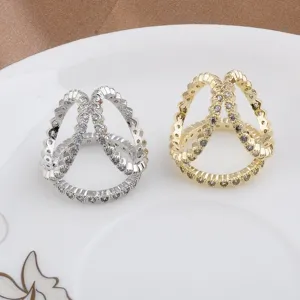 Detail view of elegant gold and silver triple ring scarf buckles with shimmering crystals.