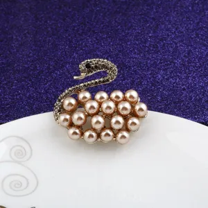 Detail view of elegant swan brooch featuring champagne pearls and sparkling crystals