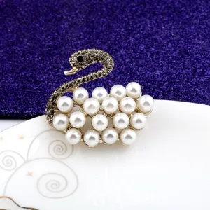Macro view showing the intricate pearl and grey rhinestone detail on an elegant swan brooch