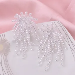 Elegante lange weiße Perlenohrringe mit Quasten für Damen auf rosa Hintergrunddekor