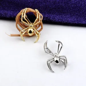 Detailansicht von goldenen und silbernen Spinnenbroschen im Punk-Stil auf Deko-Rebe.