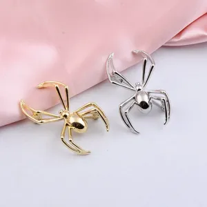 Detailansicht von stilvollen Punk-Spinne-Broschen mit glänzendem Gold- und Silberfinish