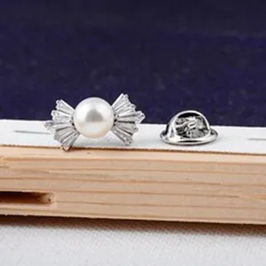 Gedetailleerde macro-opname van elegante mini parel strik broche met heldere steentjes