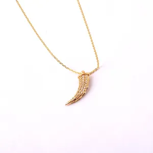Detailed macro view of an 18K gold-plated horn pendant necklace with micro-inlaid crystals