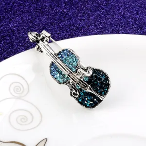 Detailed macro shot of a vintage violin brooch featuring blue gradient rhinestones
