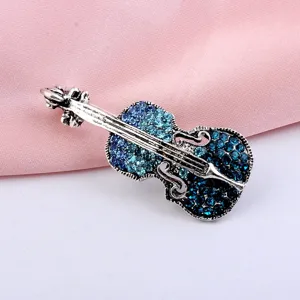 Detailed view of vintage violin brooch with blue crystal inlay and antique silver finish