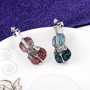 Detailed shot of vintage violin brooches encrusted with colorful gradient crystals