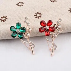 Vue détaillée de ces élégantes broches fleurs en cristal aux couleurs rouge et vert vif