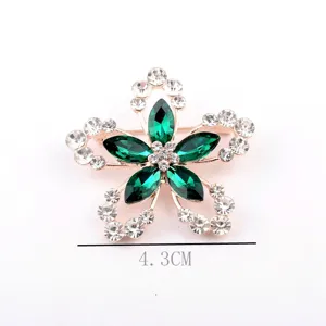 Vue détaillée d'une broche fleur à cinq pétales avec cristaux verts et taille de 4,3 cm.