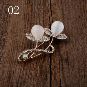 Detailaufnahme einer eleganten Blumenbrosche mit Katzenaugensteinen und Strass