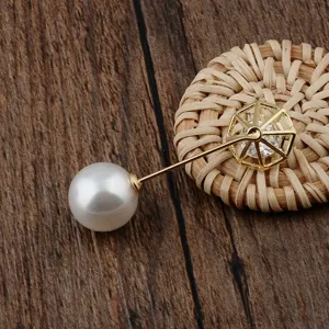 Detailaufnahme der 14K vergoldeten Brosche mit hohlem Diamanten, Zirkon und Perle