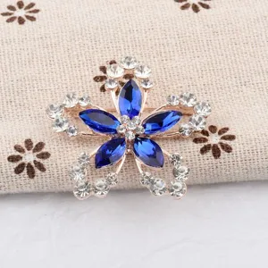 Gros plan d'une élégante broche fleur à comics pétales avec cristaux bleus et strass pour femme
