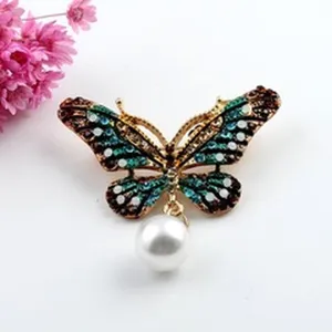 Elegant butterfly brooch with colorful crystals and a dangling white pearl charm detail