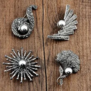 Detailed view of four vintage marcasite style silver brooches with pearls