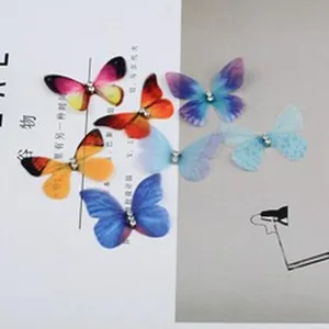 Detalle de varios dijes de mariposa bordados coloridos para proyectos de joyería de DIY.