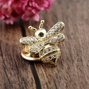 Detailed close-up of a sparkling gold bumblebee brooch with crystal rhinestones.