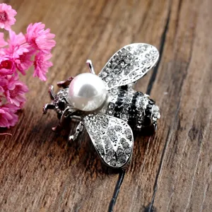 Detailaufnahme einer eleganten 3D Bienenbrosche mit Glanzperle und funkelnden Steinen