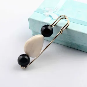 Detailansicht einer Vintage Sicherheitsnadel-Brosche in Gold mit Bernstein-Imitation