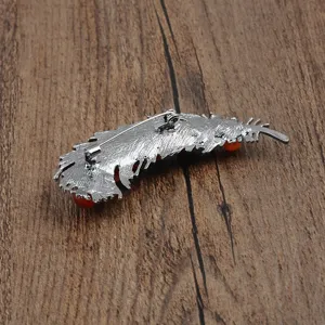 Macro detail view of the back of a feather shaped brooch with secure safety pin