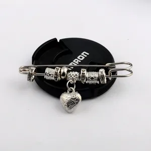 Close-up detail of a vintage silver heart brooch shawl pin featuring decorative beads