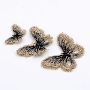 Vista macro detallada de tres parches de mariposa bordados en oro y negro para joyería DIY