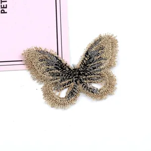 Detalle de un parche de mariposa bordado en oro y negro para manualidades DIY.