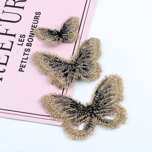 Detalle de tres parches de mariposa bordados en oro de varios tamaños para accesorios DIY