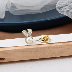 Detailansicht einer goldenen Kaninchenkopf-Anstecknadel mit Perle und Kristallen