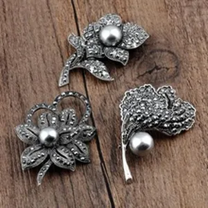 Nahaufnahme von Vintage-Blumenbroschen mit grauen Perlen und Markasit-Details