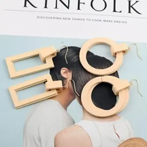Nahaufnahme von beigen geometrischen quadratischen und runden Ohrringen auf einem Magazin
