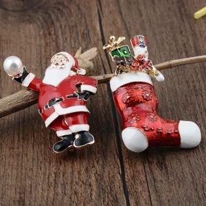 Detailaufnahme von Weihnachtsmann und Socken-Emaille-Broschen auf rustikalem Holz.