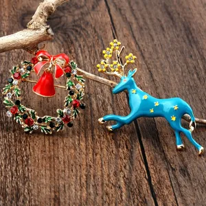 Detailansicht von festlichen Weihnachtskranz- und blauen Rentier-Emaille-Broschen