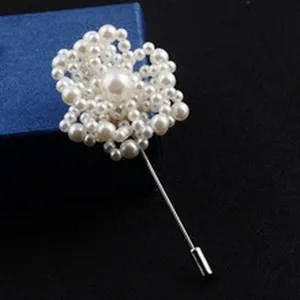 Macro view detail of a handmade white pearl flower brooch with long silver pin