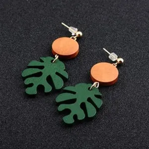 Handgefertigte Boho-Holzohrringe mit Monstera-Blatt und orangem kreisförmigem Akzent