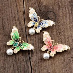 Detailansicht von drei Emaille-Schmetterlingsbroschen im Vintage-Stil mit hängenden Perlen