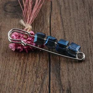 Detailansicht einer eleganten Sicherheitsnadelsbrosche mit vier dunkelblauen Kristallen