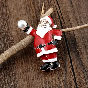 Detailansicht einer Emaille-Brosche vom Weihnachtsmann mit weißer Perle auf Holz
