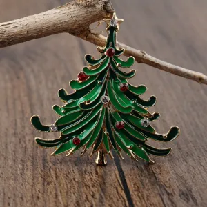Detaillierte Nahaufnahme einer grünen Emaille-Weihnachtsbaumbrosche mit roten Strasssteinen