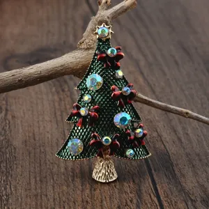 Nahaufnahme der grünen Weihnachtsbaumbrosche mit roten Schleifen und Strasssteinen