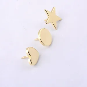 Macro detail view of minimalist golden metal pins in star circle and heart shapes