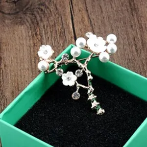 Detailopname van een elegante bloemenbroche met witte parels en fonkelende strass