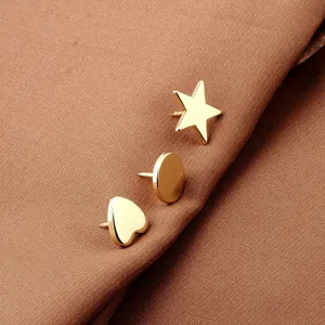 Detailed view of three minimalist gold geometric pins in star circle and heart shapes