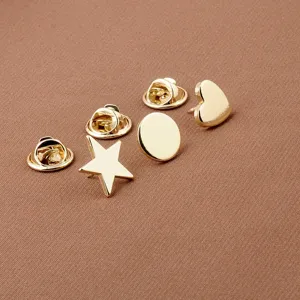 Macro detail of polished golden star heart and circle geometric metal lapel pins
