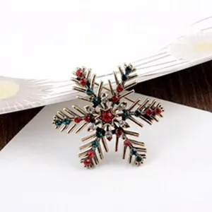 Detailopname van de rode en groene strassteentjes op de vintage sneeuwvlok broche