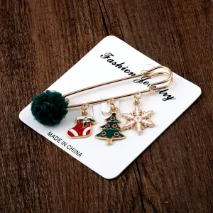 Detailansicht der weihnachtlichen Sicherheitsnadel-Brosche mit Baum- und Schneeflocken-Anhängern
