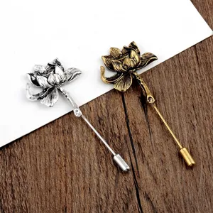 Vintage lotusbloem reversspelden in antiek zilver en goud op een houten achtergrond