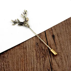 Gedetailleerde weergave van een vintage hertenkop reversspeld op hout en wit decor.