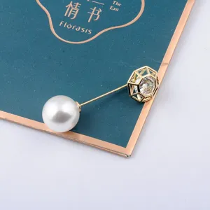 Detail einer 14K vergoldeten Brosche mit weißer Perle und hohlem geometrischem Zirkon