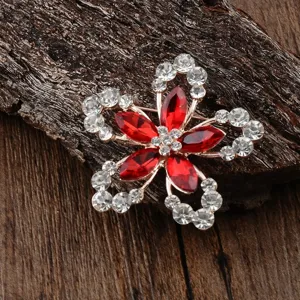 Vue détaillée d'une broche fleur élégante avec cristaux rouges et des strass clairs
